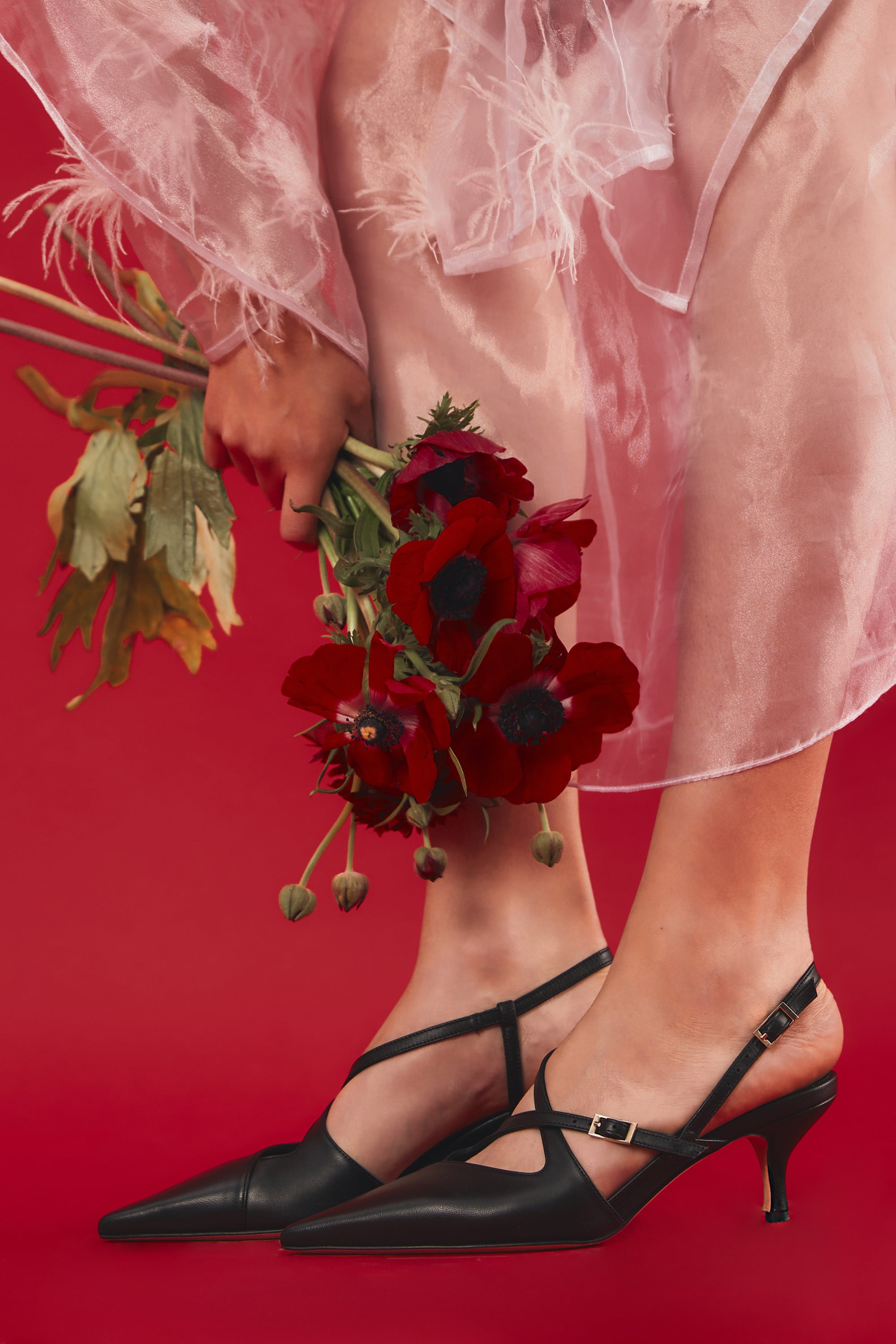 Slingback in nappa nera con cinturini incrociati e tacco a calice